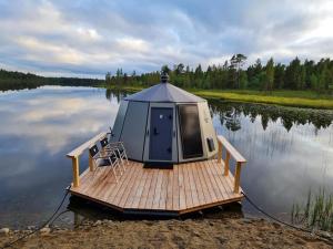 a small house on a dock on a lake at Neljän Tuulen Tupa in Kaamanen