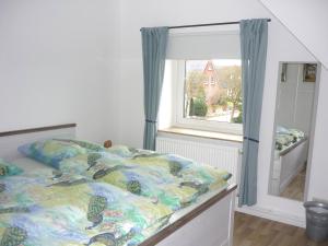 Schlafzimmer mit einem Bett und einem Fenster in der Unterkunft Ferienwohnung Hanl in Wanderup