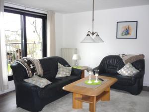 a living room with two black leather chairs and a coffee table at Ferienwohung Hanl - schöne FeWo mit 2 Schlafzimmern mit TV, Garten und großem Badezimmer in Wanderup