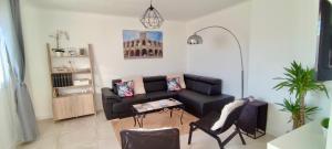 a living room with a couch and a table at Le Jardin Arlésien - Parking in Arles