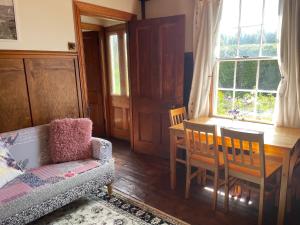 un soggiorno con tavolo, tavolo e sedie di Portobello Settler's Cottage a Portobello