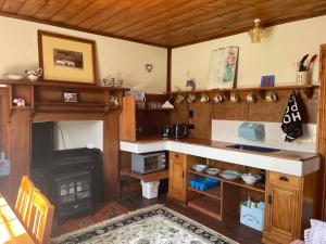 a kitchen with a fireplace and a counter with a stove at Portobello Settler's Cottage in Portobello