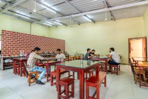 Un gruppo di uomini seduti ai tavoli in un ristorante di Guesture Serviced Residences, Alta Vista a Bangalore