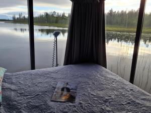 a view of a bed with a view of a lake at Neljän Tuulen Tupa in Kaamanen