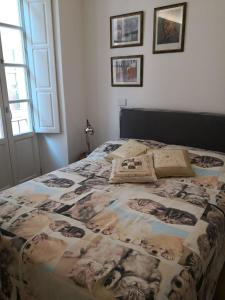 een bed in een slaapkamer met foto's aan de muur bij Casa del Conte Massimiliano Roero in Cuneo +30 foto's