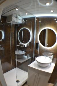 a bathroom with a toilet, sink and mirror at Ville Hotel in Manchester