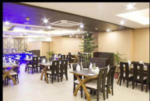 a dining room with wooden tables and chairs and sidx sidx sidx at Madhuvan Suites By Blues in Dwarka