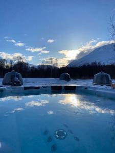 a hot tub in the snow with tents in the background at North Experience Basecamp in Melen