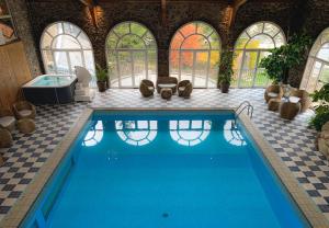 a large swimming pool in a building with windows at Hotel Llop Gris in El Tarter