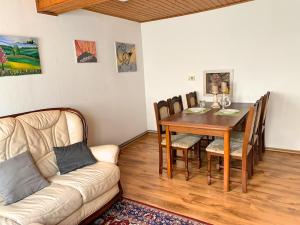 ein Wohnzimmer mit einem Tisch und einem Sofa in der Unterkunft Ferienhaus zwischen Bach und Luther mit Sauna & Garten in Eisenach