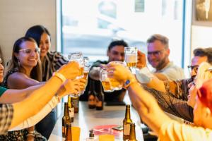 a group of people drinking beer at a bar at Hôtel Ozz by Happyculture in Nice