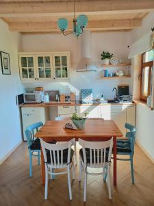 a kitchen with a wooden table and chairs at Gazdówka - najlepsza miejscówka domek w Pieninach in Krościenko
