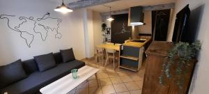 a living room with a couch and a table and a kitchen at Les gîtes de la Brasserie d'Aubrives La Malterie et la Houblonnière in Aubrives