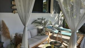 a living room with a couch and a table at Casa Aix Keys avec jacuzzi privatif proche plages et Golf in Saint-Laurent-de-la-Prée