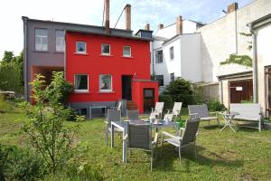 einen Hof mit einem Tisch und Stühlen sowie einem roten Gebäude in der Unterkunft Fewo auf der Dominsel-DOMLINDEN in Brandenburg an der Havel