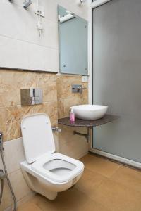 a bathroom with a white toilet and a sink at Lime Tree Luxurious 3BHK Serviced Apartment Near Medanta in Gurgaon