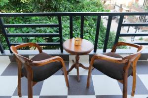 2 sillas y una mesa en el balcón en Lime Tree Luxurious 3BHK Serviced Apartment Near Medanta, en Gurgaon