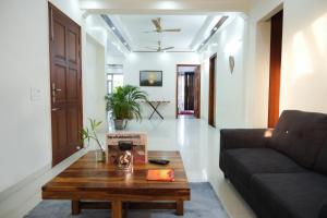 a living room with a couch and a coffee table at Lime Tree Luxurious 3BHK Serviced Apartment Near Medanta in Gurgaon