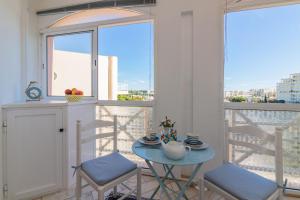 ヴィラモウラにあるVilamoura Main Avenue by Homingのバルコニー付きの客室で、小さなテーブルと椅子が備わります。