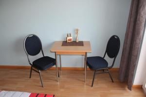 a table and two chairs in a room with a table at Hotel Birten in Xanten