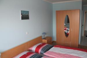 een slaapkamer met een bed en een spiegel bij Hotel Birten in Xanten