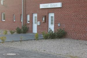 een bakstenen gebouw met een bord waarop staat: huid gebeten bij Hotel Birten in Xanten