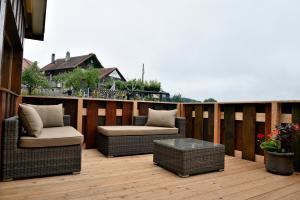 eine Terrasse mit Korbstühlen und einem Tisch auf einer Terrasse in der Unterkunft Cabane dans les arbres / Swin-golf de Cremin in Cremin