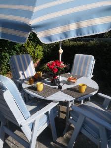 a table with two chairs and an umbrella at Chambres d'Hôtes Le Mas du Bijou Bleu in Puget-sur Argens