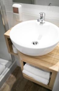 a bathroom with a white sink on a wooden shelf at Best Hotel Bordeaux Sud in Villenave-dʼOrnon +32 photos