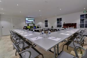 una gran sala de conferencias con una mesa grande y sillas en Chateau des Fontenelles en Chavagne