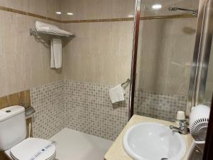 a bathroom with a shower and a toilet and a sink at Apartahotel FC Catedral in León