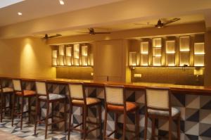 a bar in a restaurant with stools at Sharayu One in Mapusa