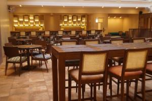um restaurante com mesas e cadeiras num quarto em Sharayu One em Mapuçá