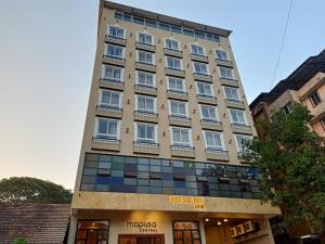 a tall building with a store in front of it at Sharayu One in Mapusa