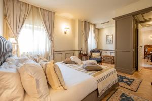 una camera da letto con un grande letto con lenzuola bianche di Relais Colle San Pietro a Verona