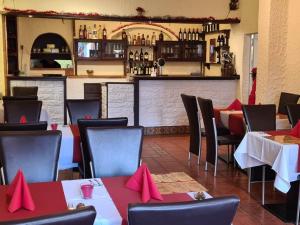 a restaurant with tables and chairs with red napkins at Hotel am Schloss in Frankfurt/Main