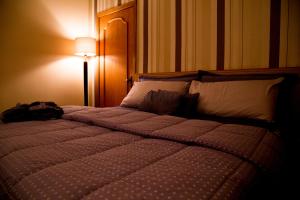 a bedroom with a large bed with a light on at Hotel Golden Park Uberaba in Uberaba