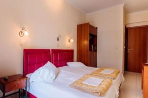 a bedroom with a large bed with a red headboard at Christina Hotel in Olympic Beach