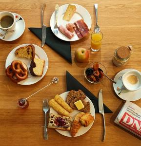 a table with plates of breakfast foods and a cup of coffee at Hotel Victoria in Strasbourg