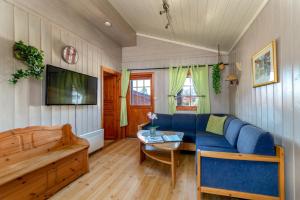 - un salon avec un canapé bleu et une table dans l'établissement First Camp Bø - Telemark, à Bø