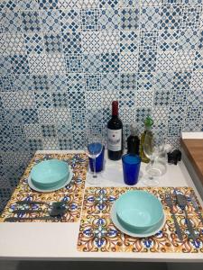 a table with plates and wine glasses on a counter at Casa Maradona in Naples