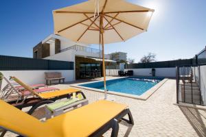 una piscina con sombrilla amarilla, sillas, mesa y piscina en Alto da Colina - Vila Moderna e Espaçosa - Top Localização, en Pêra
