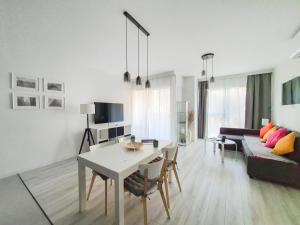 sala de estar con mesa y sofá en Capital Apartments - Towarowa, en Poznan