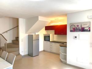 a kitchen with a stainless steel refrigerator and stairs at Villa Marilyn in Ledro