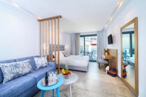 a living room with a blue couch and a table at Studios Nautilus III in Potos