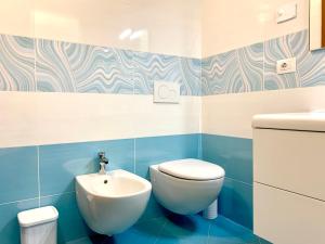 a blue and white bathroom with a toilet and a sink at Villa Marilyn in Ledro