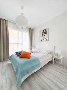 a white bedroom with a large bed and a window at Capital Apartments - Towarowa in Poznań