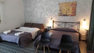 two beds in a room with two chairs and a painting at Relais Il Giardino fra gli Ulivi in Torino di Sangro +96 photos