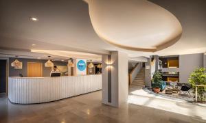 lobby hotelu z kobietą stojącą przy ladzie w obiekcie Sunny Krk by Valamar w Krku