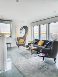 a living room with a couch and chairs and windows at Capital Apartments - Towarowa in Poznań